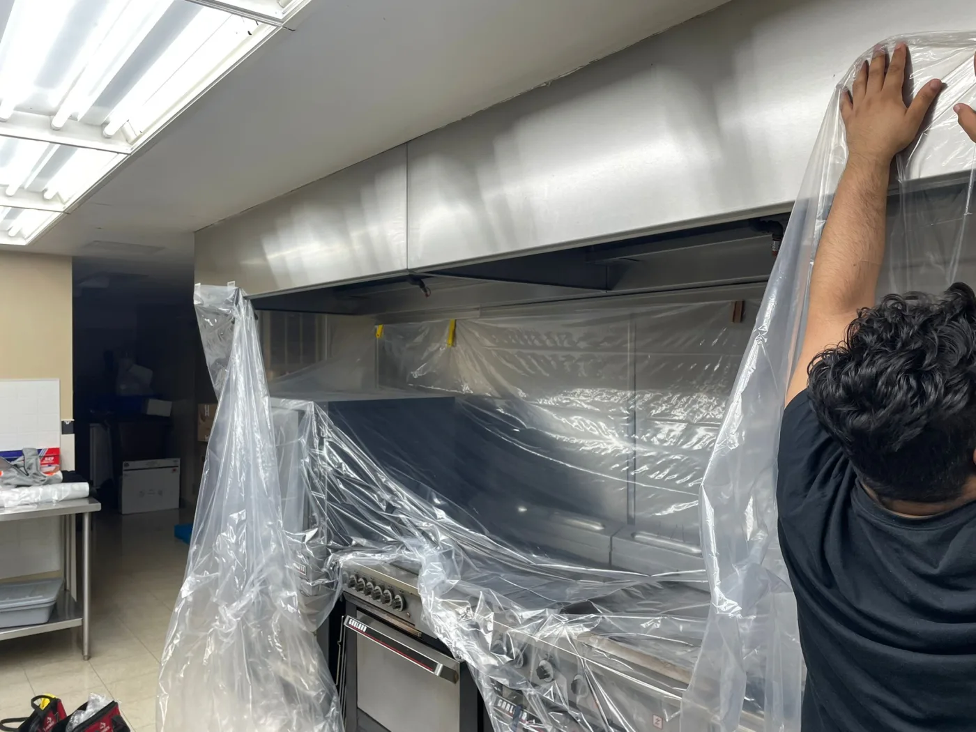 Ontario Hood Cleaning technician inside a commercial kitchen hood during an overnight after-hours service call